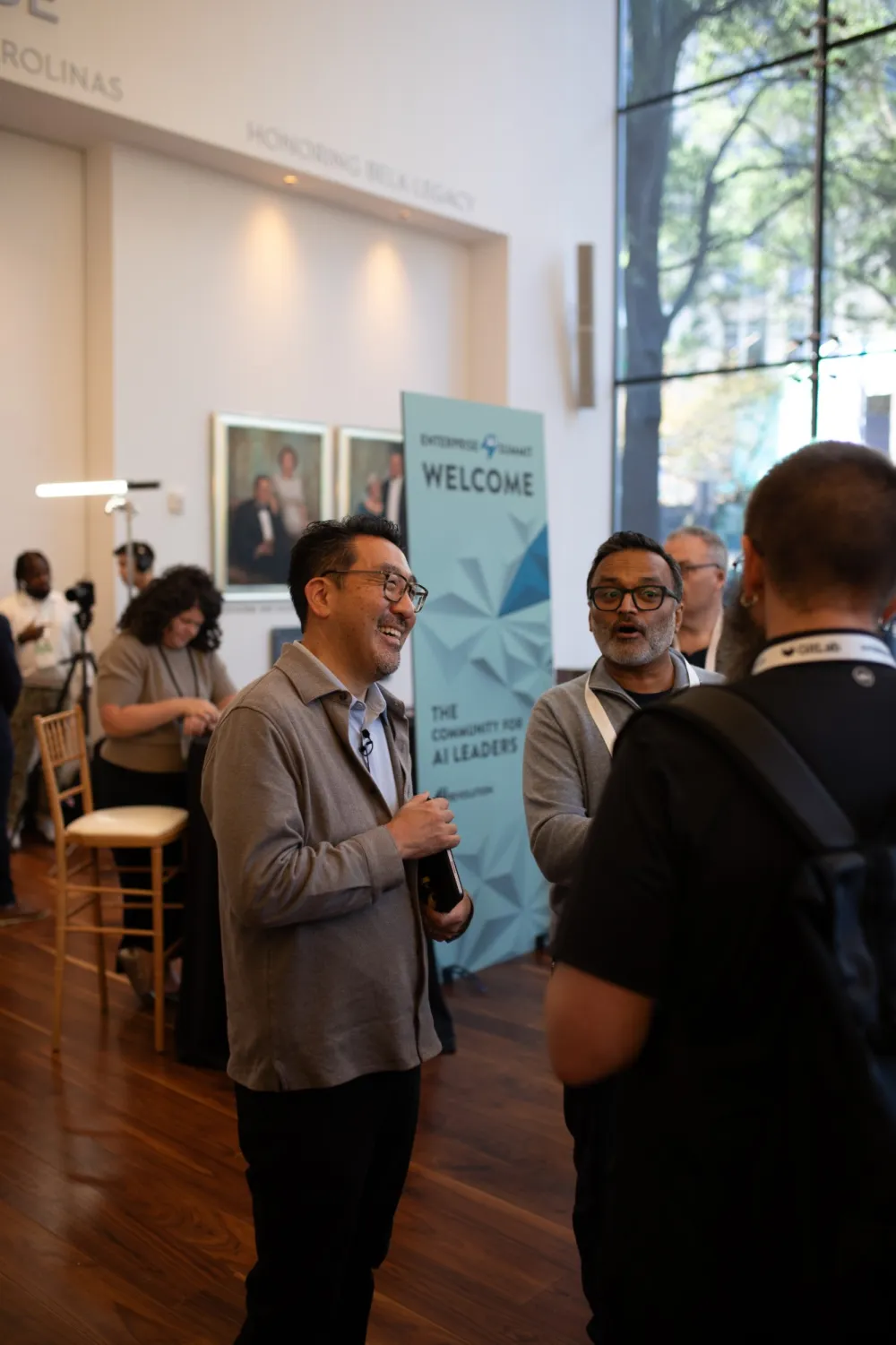 Attendees greeting each other by the Welcome banner